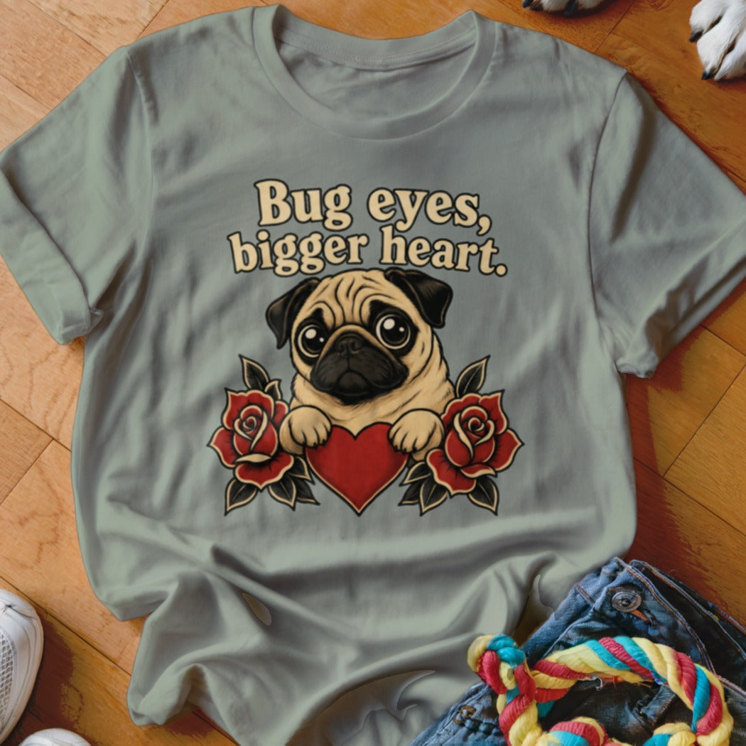 Pug with text "Bug eyes, bigger heart" and roses on a t-shirt.