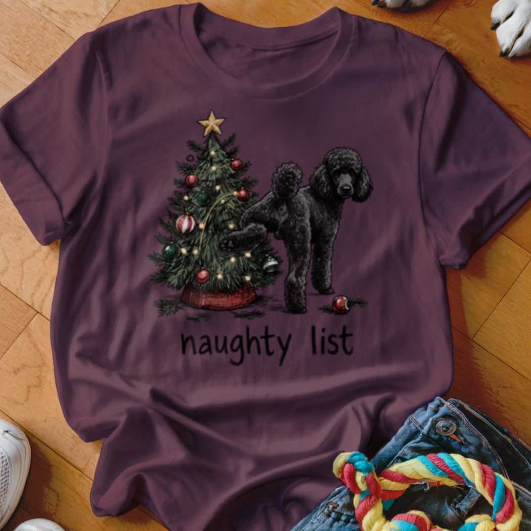 Black poodle near Christmas tree with text "naughty list".