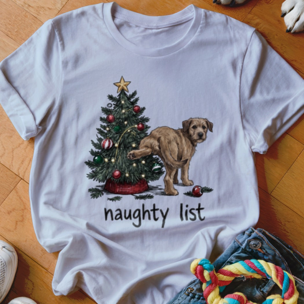 White t-shirt with a graphic of a dog peeing on a Christmas tree above the text "naughty list".