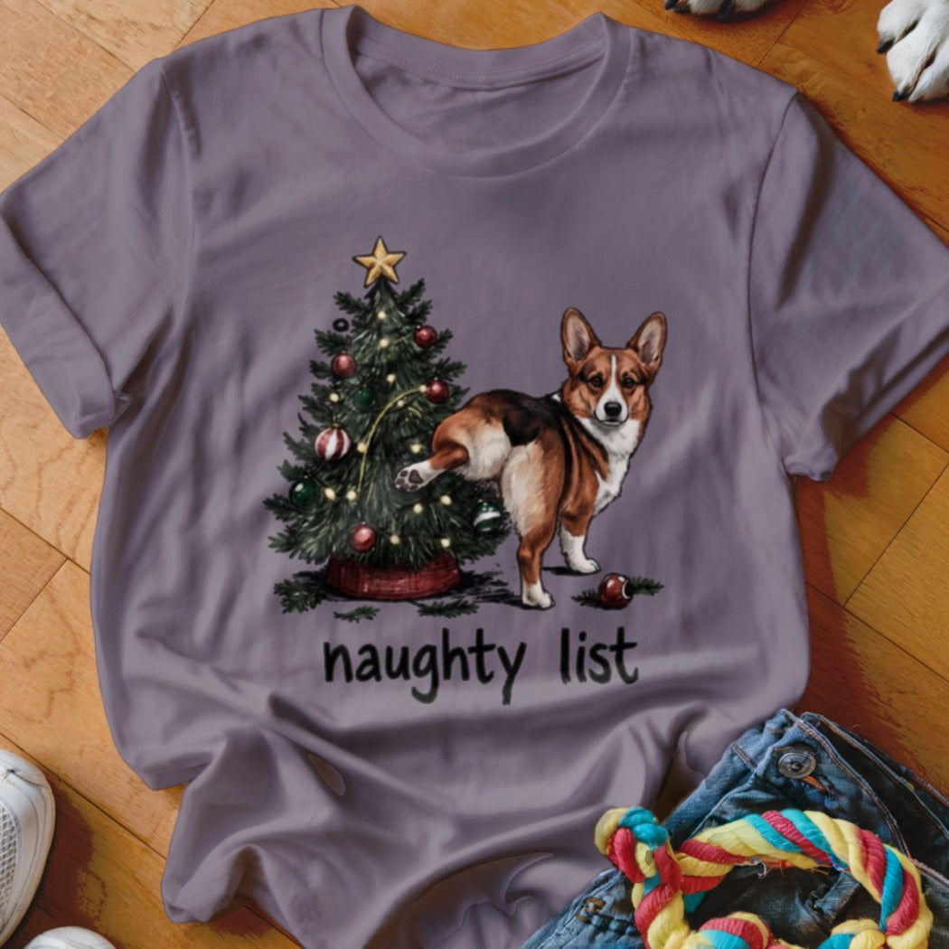 T-shirt graphic: Corgi dog by Christmas tree with text "naughty list"
