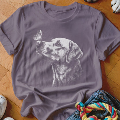 A purple short-sleeved t-shirt featuring a white sketched graphic of a dog looking at a butterfly.