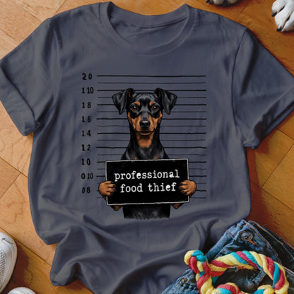 Dog with a "professional food thief" sign in front of a mugshot background.