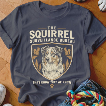 A dark grey t-shirt featuring a crest with a dog and the text The Squirrel Surveillance Bureau.
