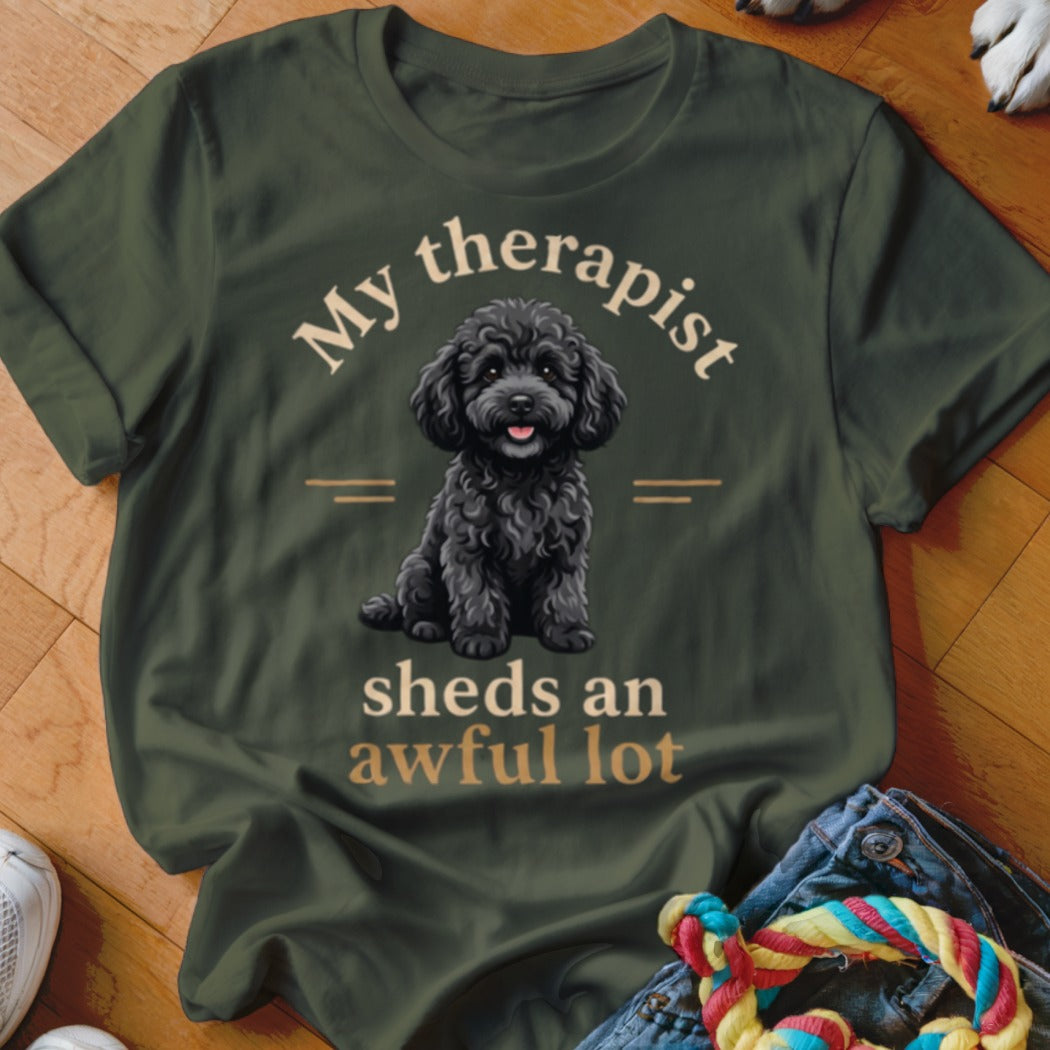 Green t-shirt with a black poodle illustration and text "My therapist sheds an awful lot".