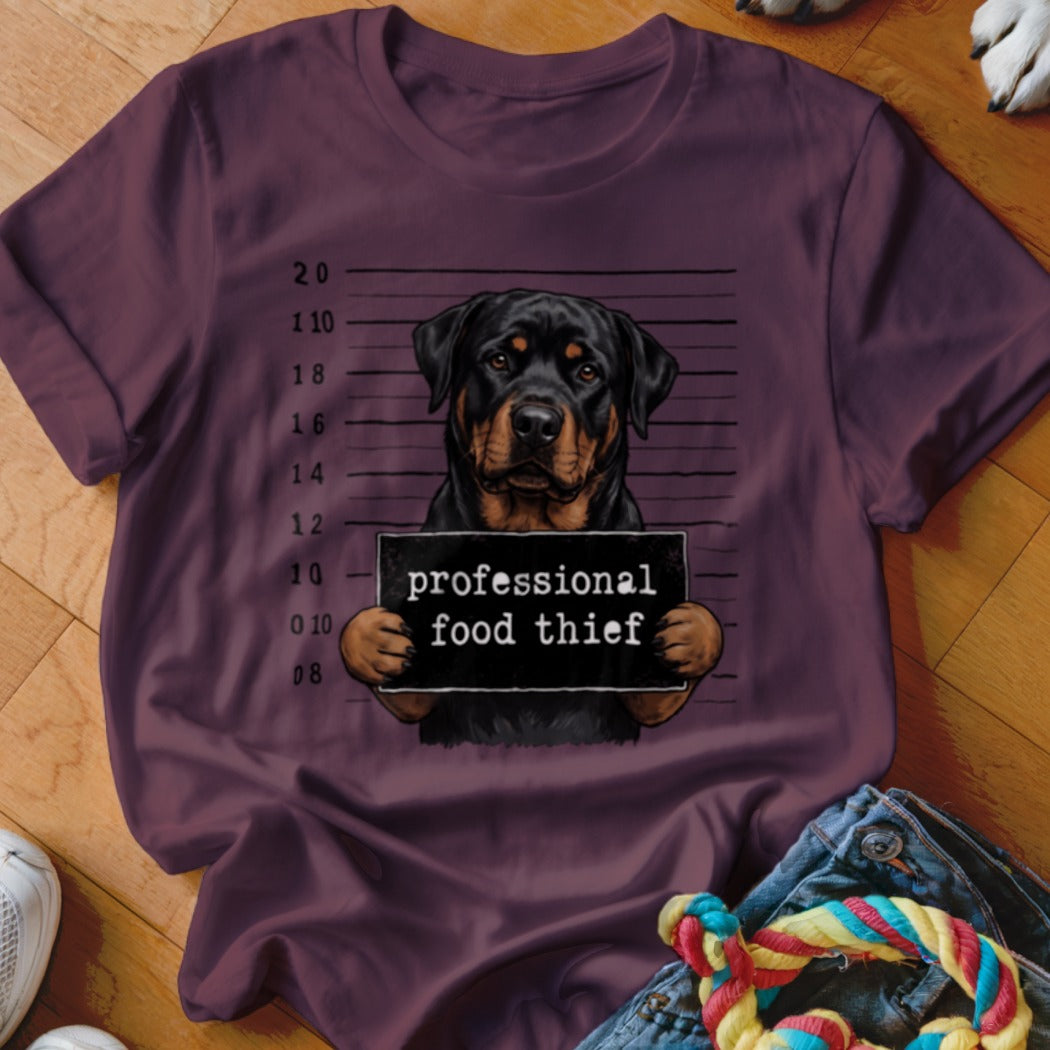 Rottweiler mugshot with sign reading "professional food thief."