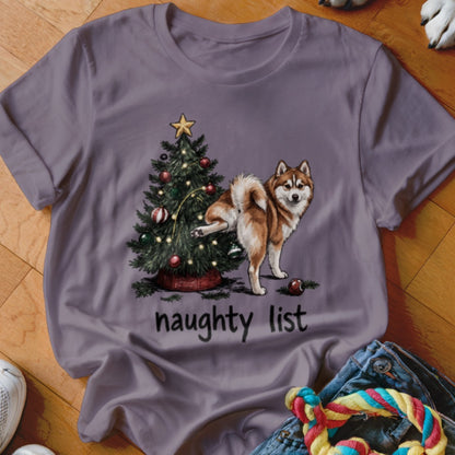 Husky dog by Christmas tree with "naughty list" text on purple t-shirt.