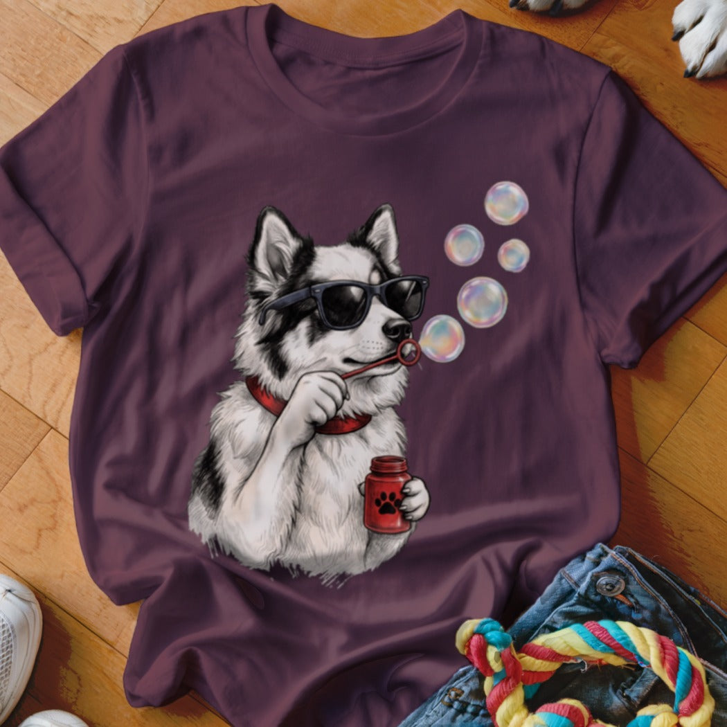 Maroon t-shirt featuring a graphic of a black and white dog wearing sunglasses and blowing bubbles.