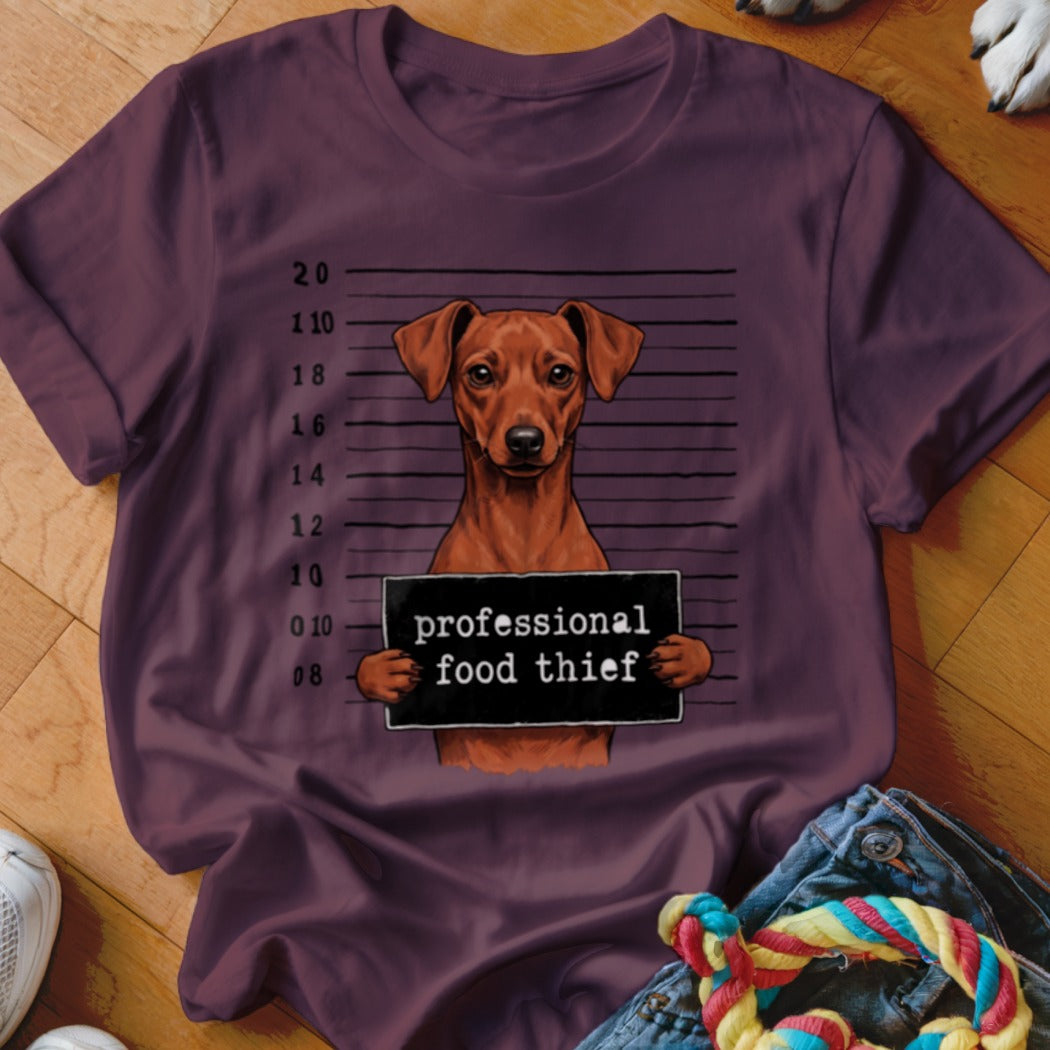 Brown dog with mugshot sign reading "professional food thief".
