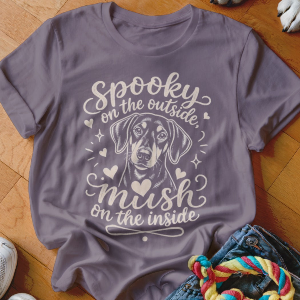 Purple t-shirt with dog illustration and text "Spooky on the outside, mush on the inside".