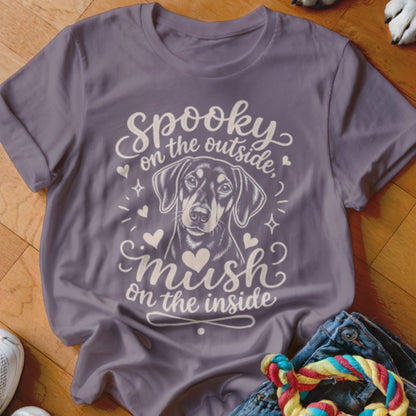 Purple t-shirt with dog illustration and text "Spooky on the outside, mush on the inside".