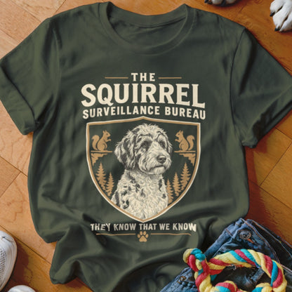 Dark green t-shirt featuring a dog graphic, crest, squirrels, and the text "The Squirrel Surveillance Bureau".