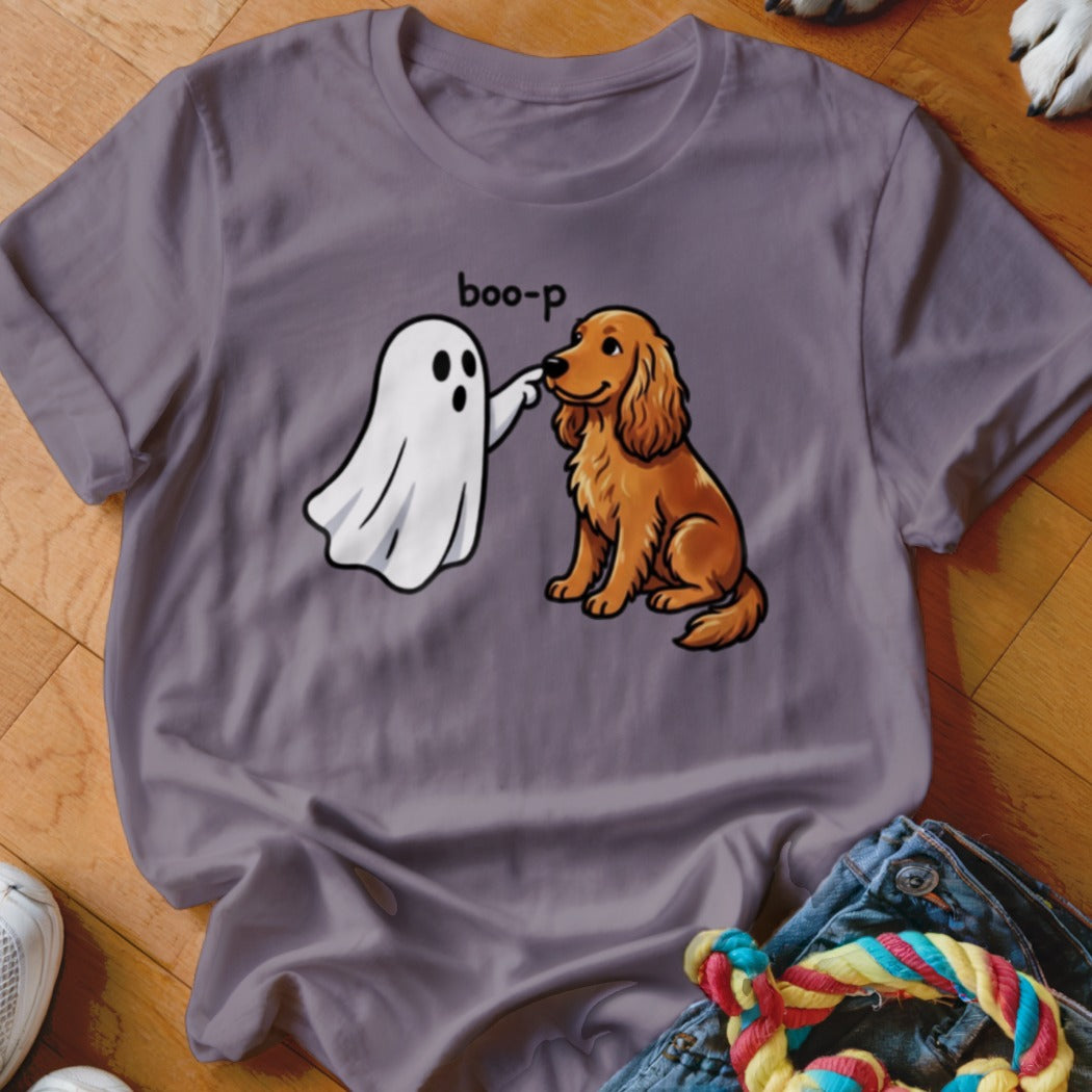 Cartoon ghost boops nose of brown dog on purple t-shirt.