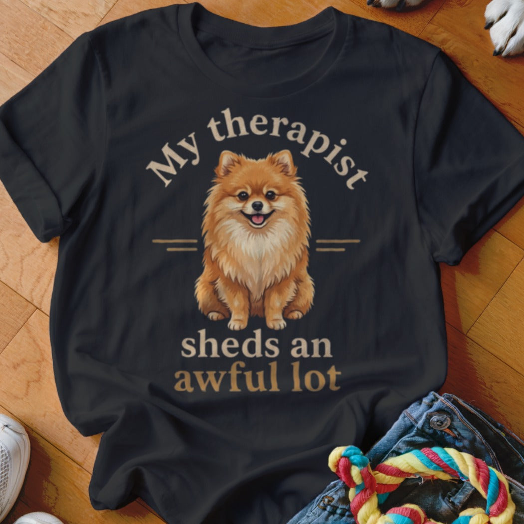 Dark t-shirt with a happy Pomeranian and text "My therapist sheds an awful lot".