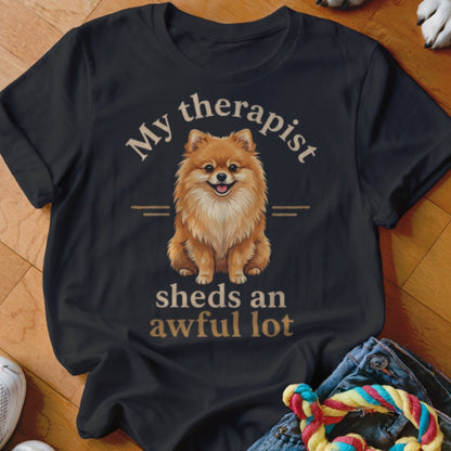 Dark t-shirt with a happy Pomeranian and text "My therapist sheds an awful lot".