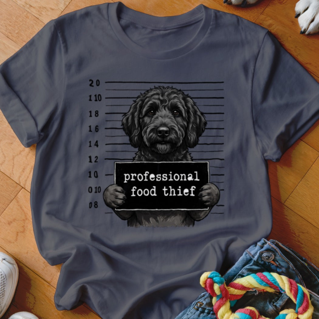 T-shirt graphic of a black dog holding a "professional food thief" sign in front of a mugshot background.
