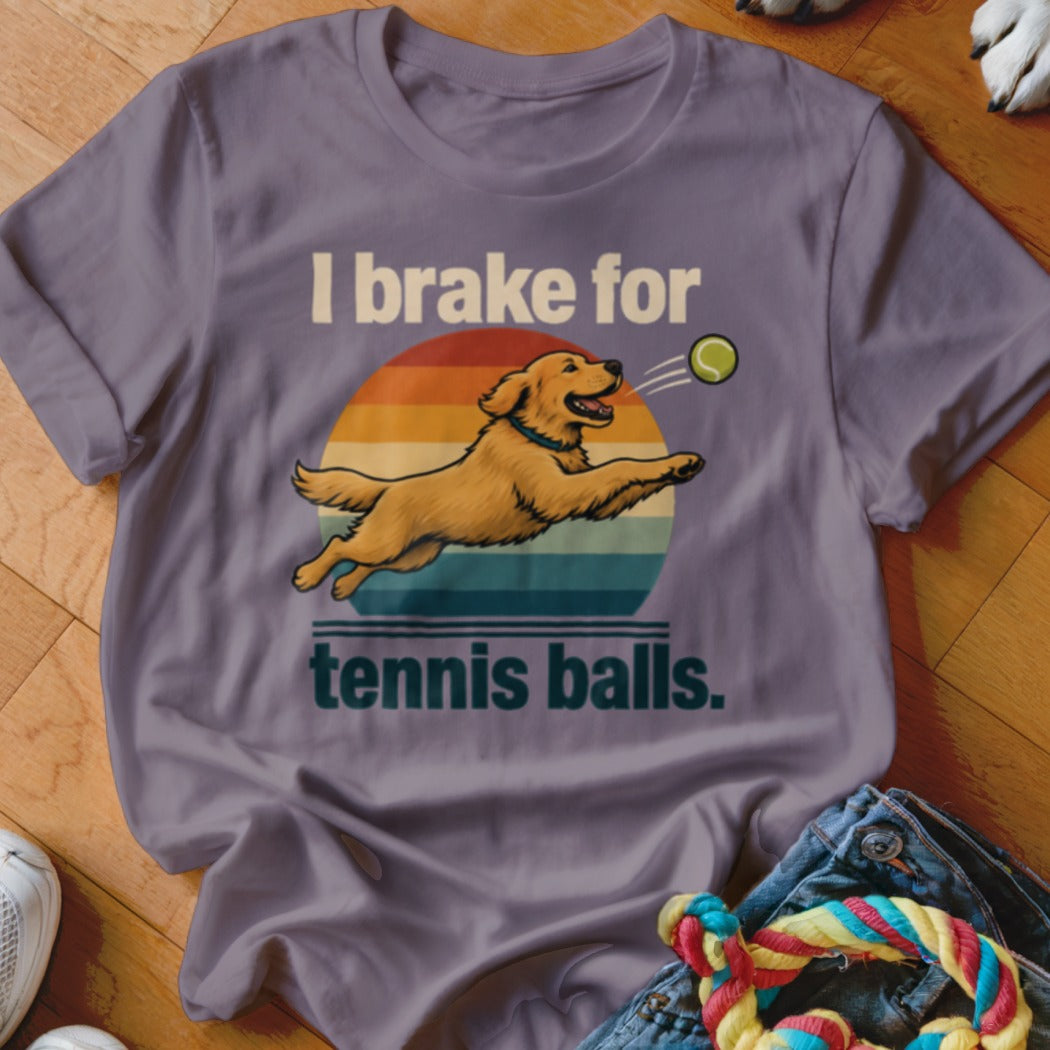 Golden retriever jumps for tennis ball with text "I brake for tennis balls."