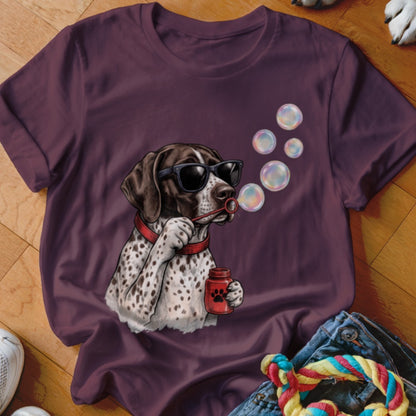 A dark purple t-shirt featuring a graphic of a spotted dog wearing sunglasses and blowing bubbles.
