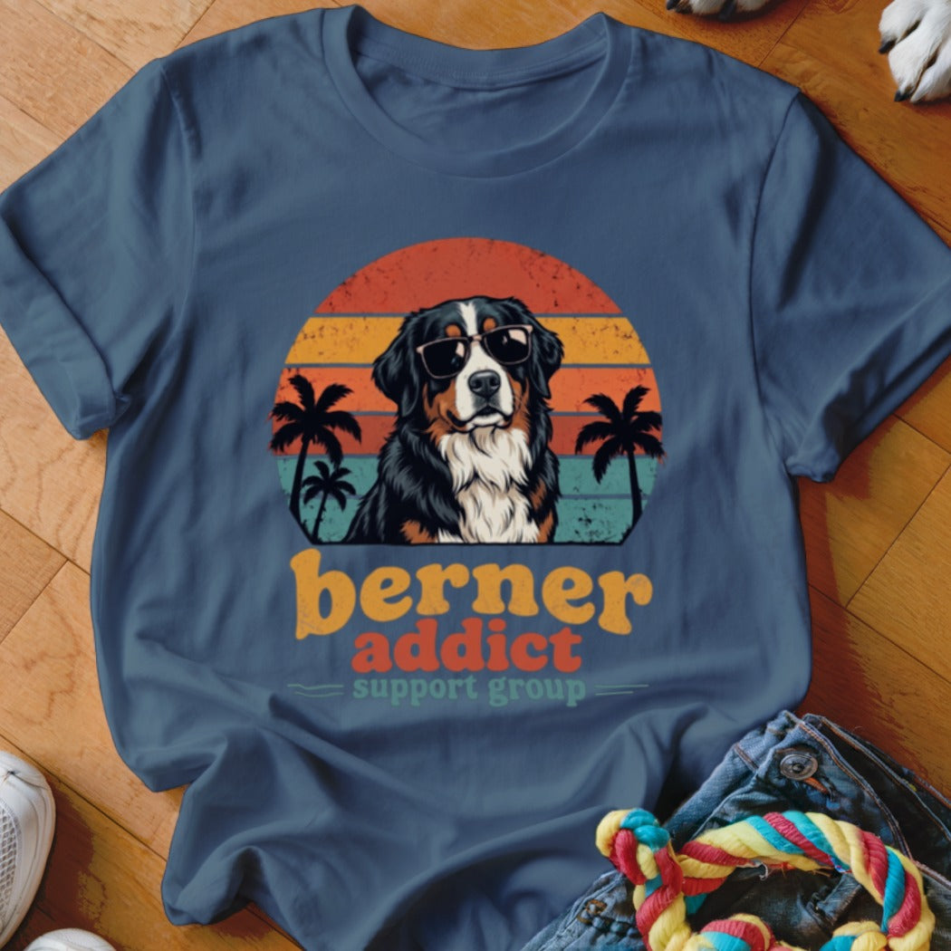 Blue t-shirt featuring a Bernese Mountain Dog wearing sunglasses in front of a sunset with palm trees and text reading berner addict support group.