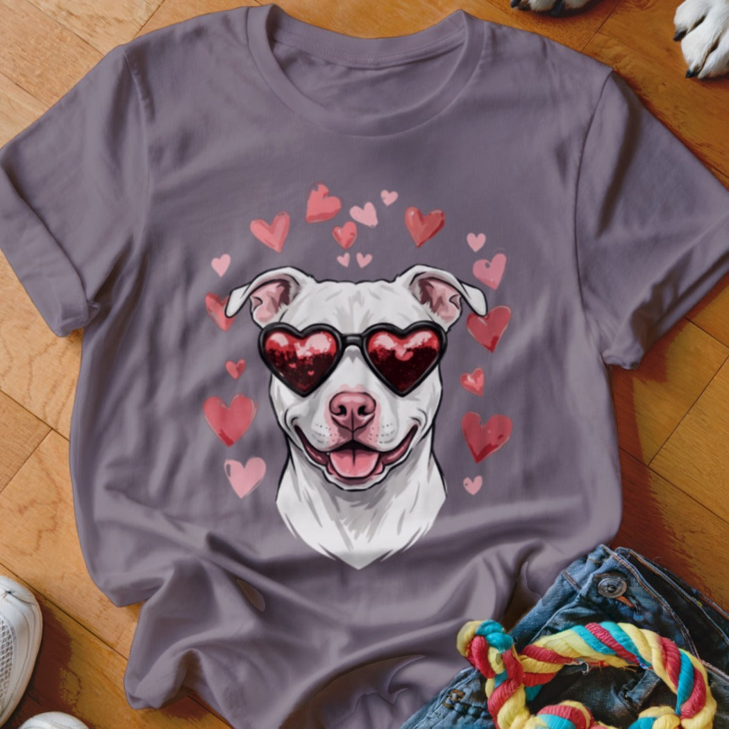 A mauve short-sleeve t-shirt featuring a graphic of a white dog wearing heart-shaped sunglasses surrounded by pink hearts.
