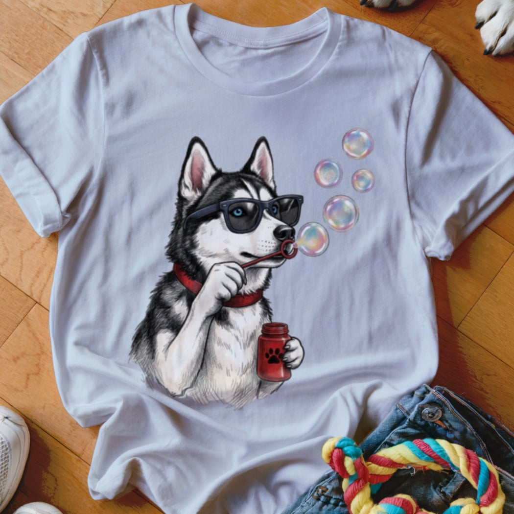 A white crewneck t-shirt featuring a graphic of a husky wearing sunglasses and blowing soap bubbles.