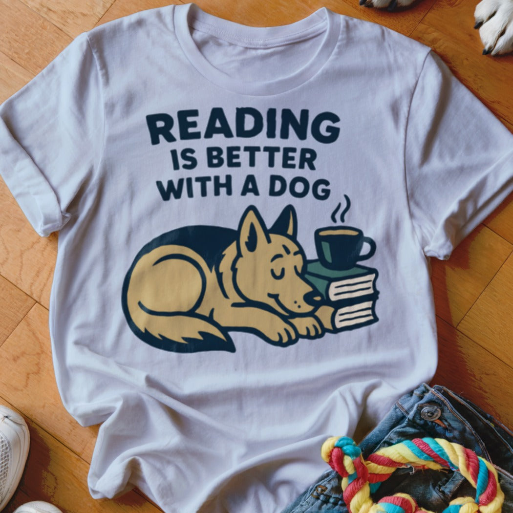 White t-shirt with "Reading is Better With a Dog" text above a dog sleeping on books with coffee.
