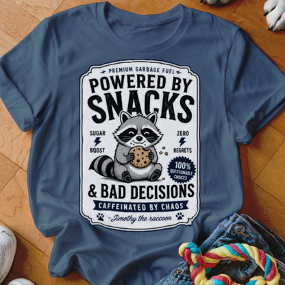 Dark blue t-shirt with raccoon holding cookie and text "Powered by Snacks & Bad Decisions".