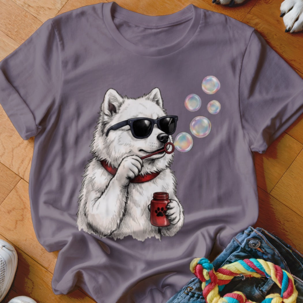 A grey t-shirt featuring a graphic of a white dog wearing sunglasses and blowing bubbles.
