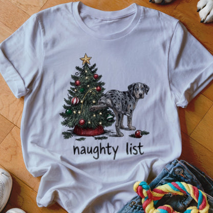 White t-shirt with a graphic of a spotted dog lifting its leg on a Christmas tree, with the text naughty list.