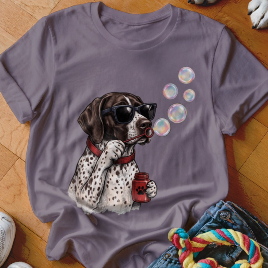 Purple t-shirt featuring a graphic of a spotted dog wearing sunglasses and blowing soap bubbles.