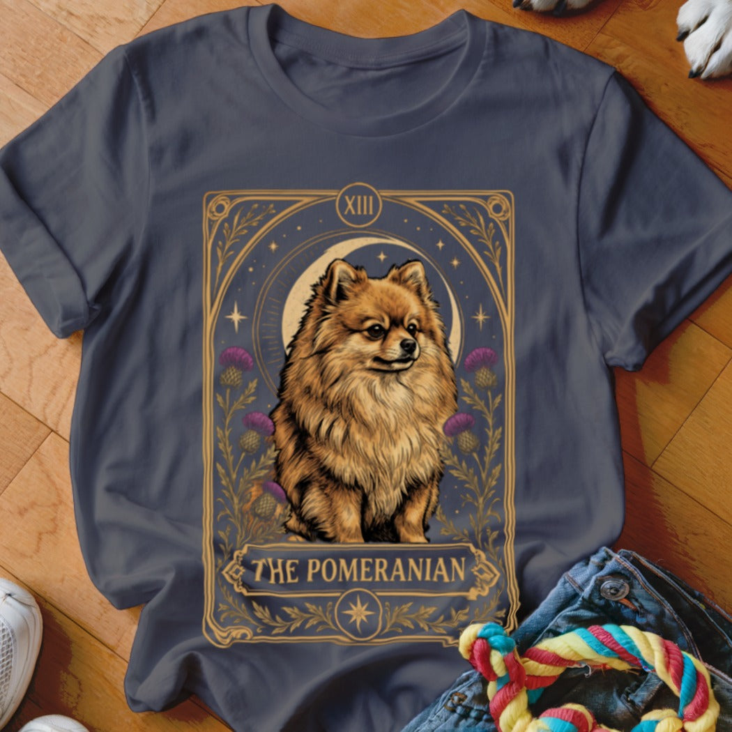 A dark gray t-shirt featuring a tarot card graphic of a Pomeranian with purple flowers and a crescent moon.