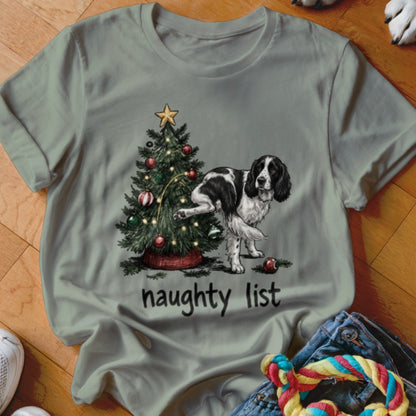 English Springer Spaniel by a Christmas tree with text "naughty list".