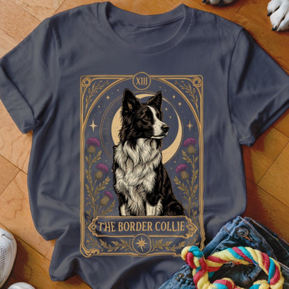 A charcoal gray t-shirt featuring a tarot card style graphic of a Border Collie surrounded by flowers and a crescent moon.
