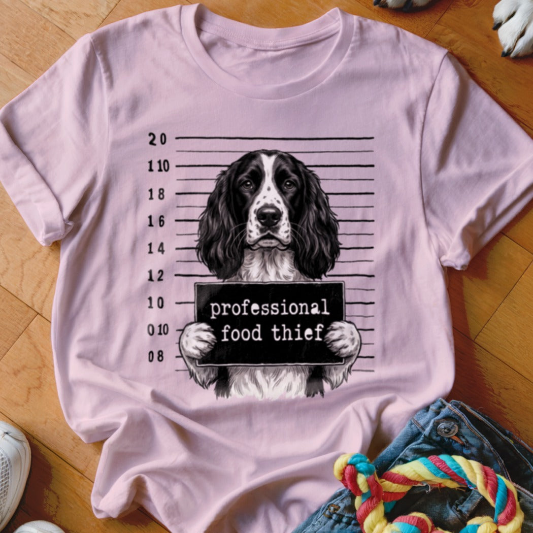Springer Spaniel mugshot with "professional food thief" text on a pink t-shirt.