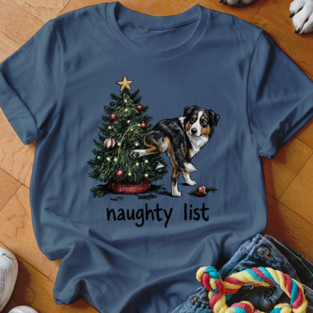 T-shirt graphic of a dog by a Christmas tree with the text "naughty list".
