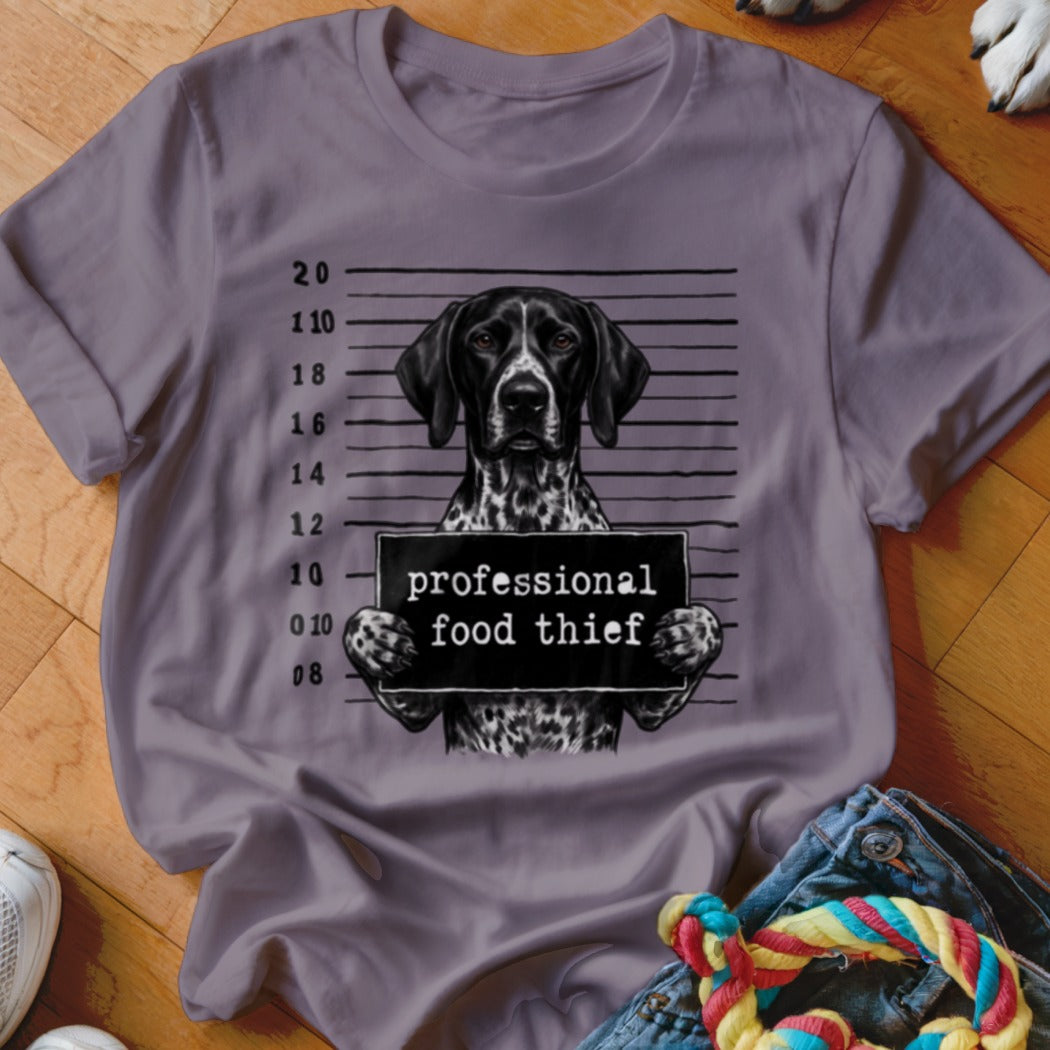 German Shorthaired Pointer in mugshot holding "professional food thief" sign.