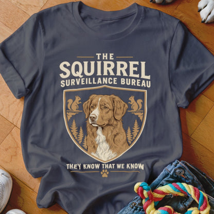 Dark grey t-shirt featuring a graphic emblem of a brown dog with text reading The Squirrel Surveillance Bureau.