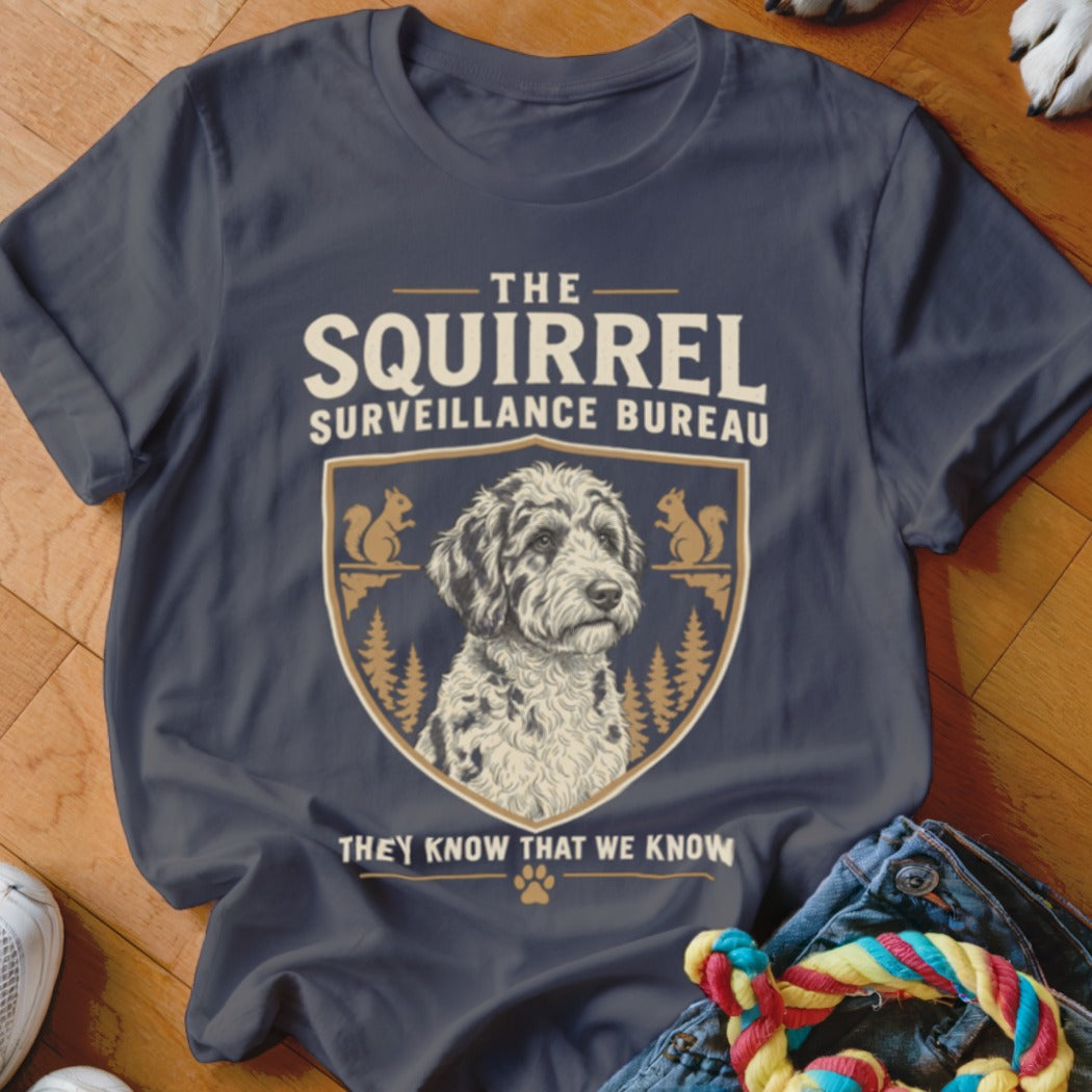 Dark gray t-shirt featuring a crest with a doodle dog, pine trees, squirrels, and text.