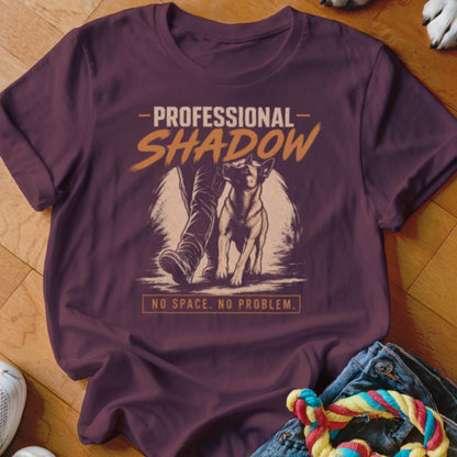 Maroon t-shirt with "PROFESSIONAL SHADOW" graphic and a dog walking next to a person's legs.