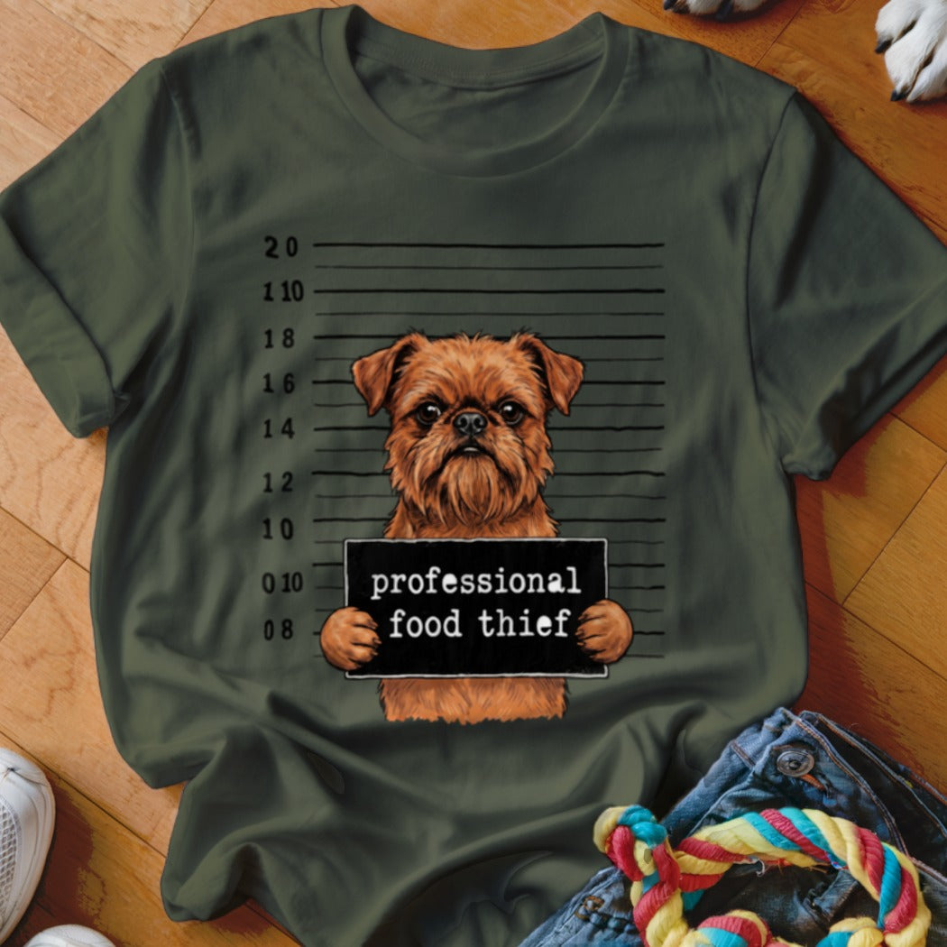 Brussels Griffon dog with "professional food thief" sign on mugshot background.