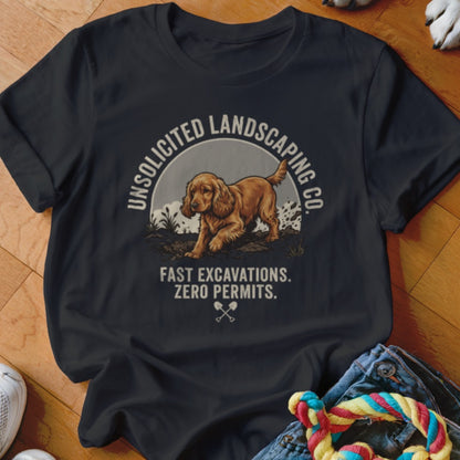 Dark t-shirt with a golden dog and "Unsolicited Landscaping Co. Fast Excavations. Zero Permits." text.