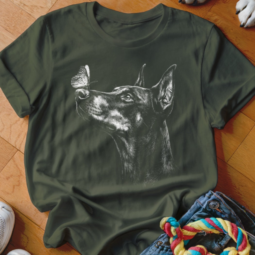 Dark green t-shirt featuring a white sketch graphic of a Doberman dog with a butterfly on its nose.
