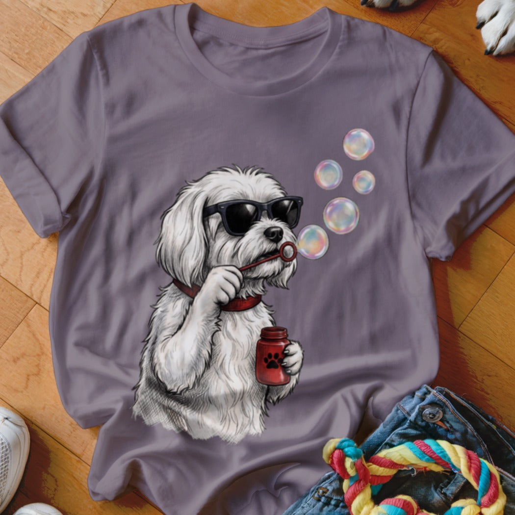 A gray t-shirt featuring a graphic of a white dog wearing sunglasses and blowing bubbles.