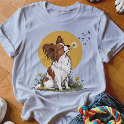 White crewneck t-shirt featuring a graphic of a brown and white Papillon dog blowing a dandelion.