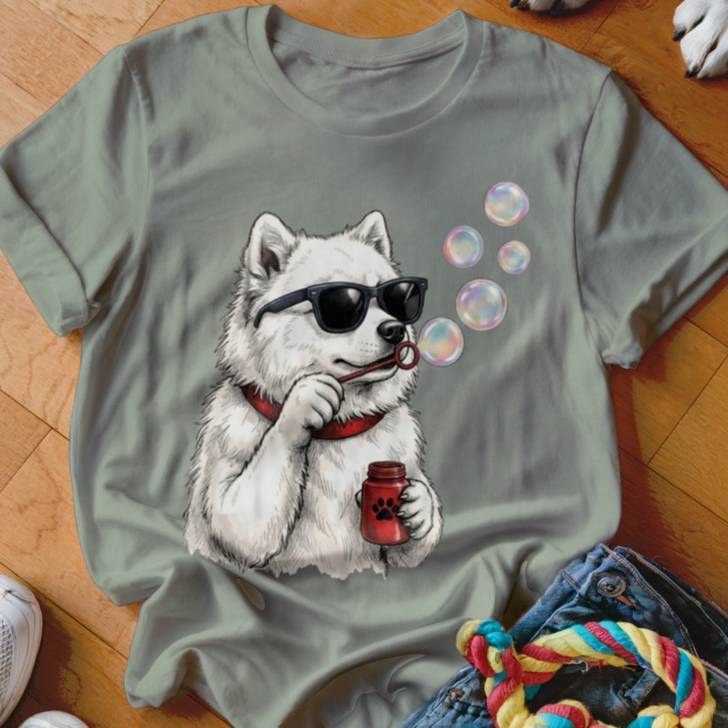 Olive green t-shirt featuring a graphic of a white dog wearing sunglasses and blowing bubbles.