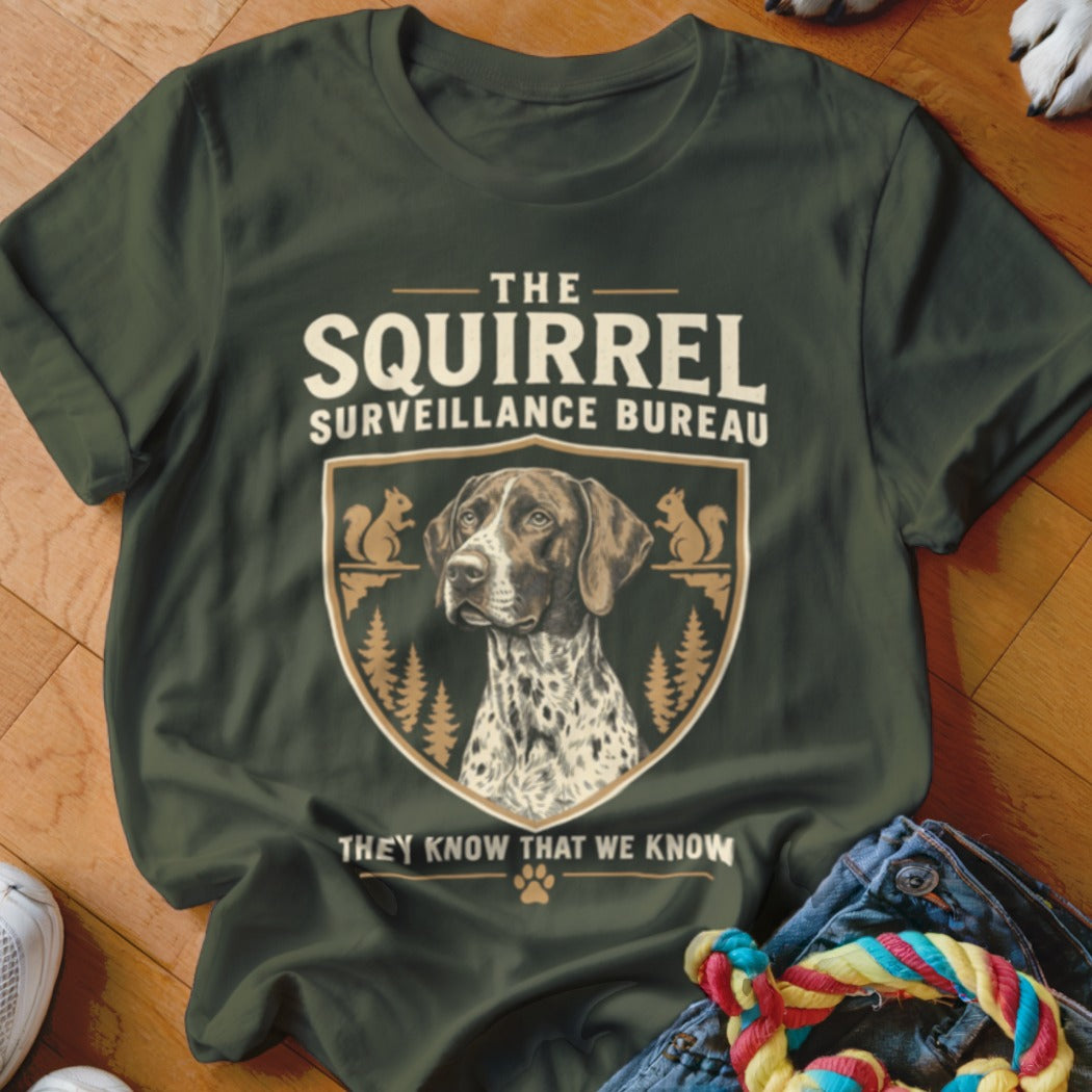 Dark green t-shirt featuring a crest with a pointer dog and squirrels, reading The Squirrel Surveillance Bureau.
