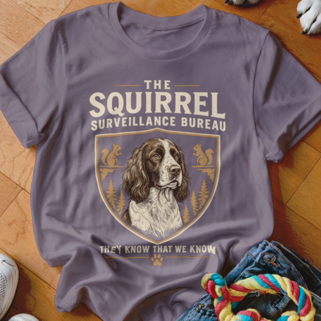 A mauve t-shirt with a graphic of an English Springer Spaniel and text reading The Squirrel Surveillance Bureau.