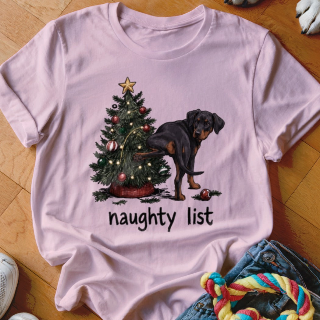 Black and brown dog next to Christmas tree, with "naughty list" text.