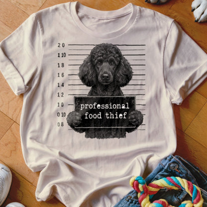 T-shirt graphic of a black poodle holding a sign that says "professional food thief".