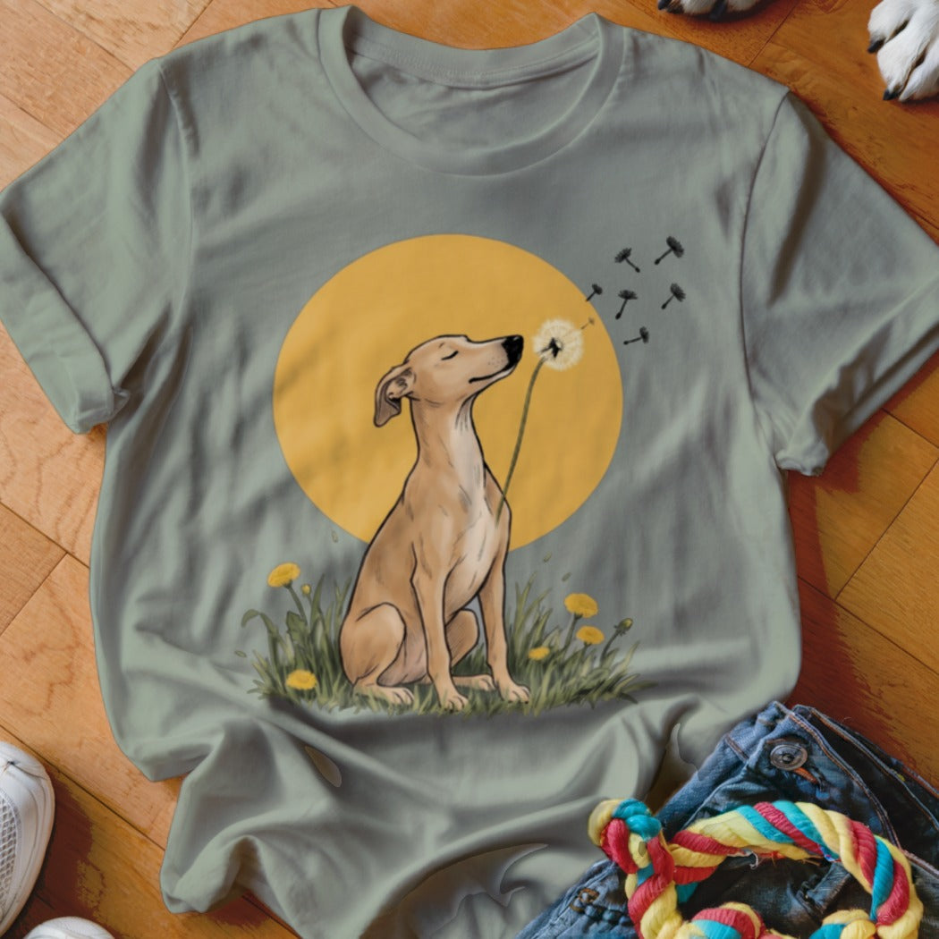 Olive green t-shirt featuring an illustration of a brown dog blowing dandelion seeds against a yellow sun.