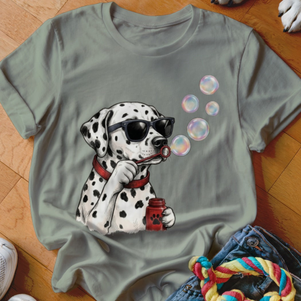 Sage green t-shirt featuring an illustration of a Dalmatian wearing sunglasses and blowing bubbles.